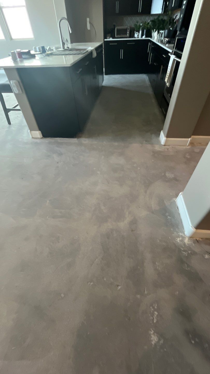 Finished kitchen with dark cabinets and a clean concrete floor